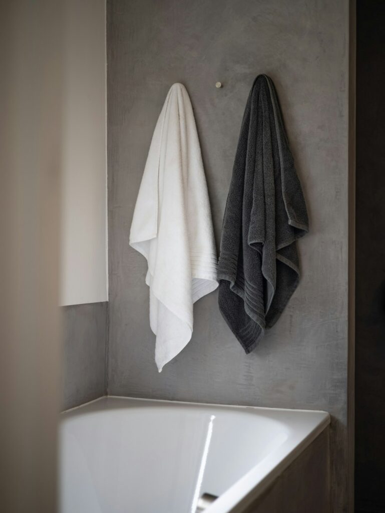 white bath towel on white ceramic bathtub